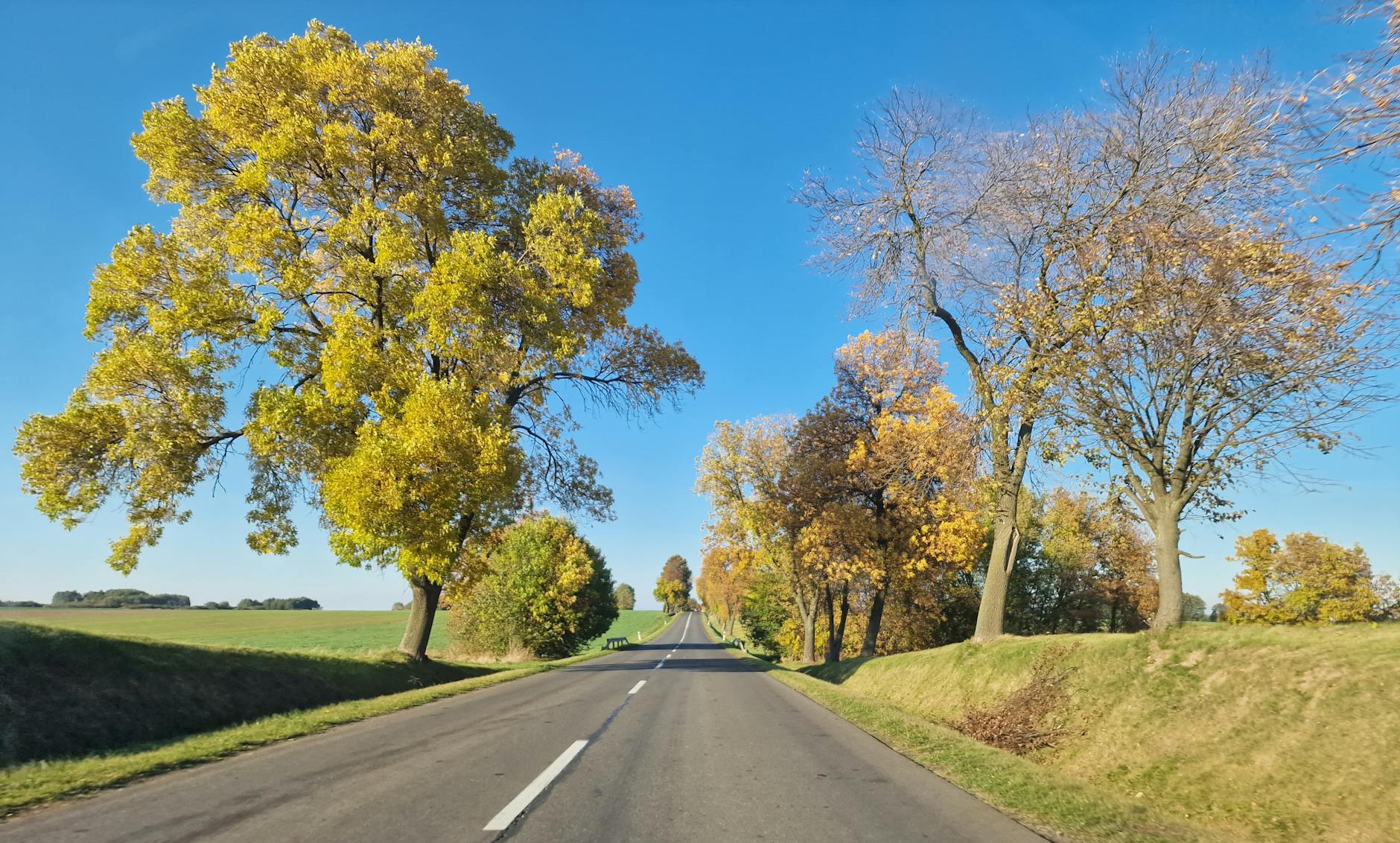 Plakat informacyjny o milionach złotych na inwestycje drogowe w Powiecie Kłodzkim i Ząbkowickim.